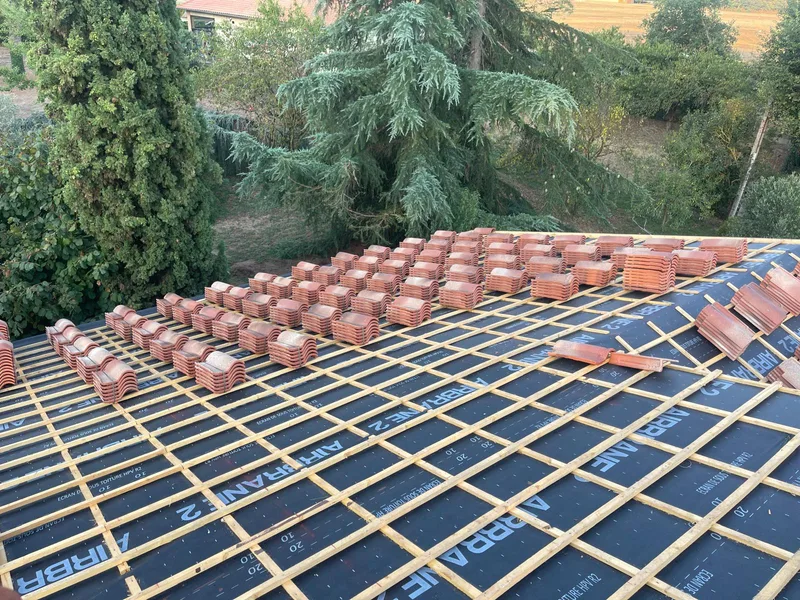 Pose de tuiles sur toiture en cours de rénovation
